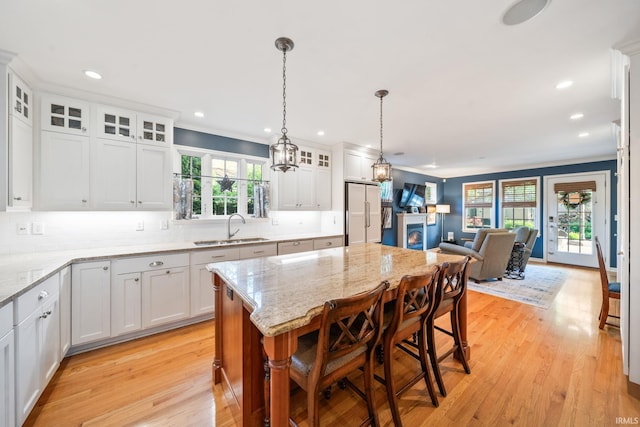 1327 E Wayne St, South Bend, IN 46615 - kitchen with a sink, open floor plan, light wood-style flooring, white cabinets, and backsplash