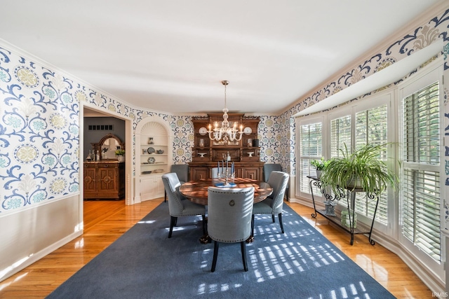 1327 E Wayne St, South Bend, IN 46615 - dining space with wallpapered walls, a chandelier, crown molding, baseboards, and light wood-style flooring