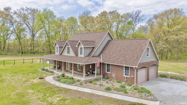 view of front facade with brick siding, a shingled roof, asphalt driveway, and a porch