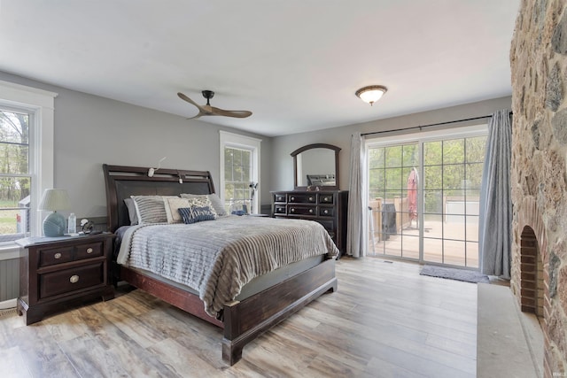 bedroom with access to outside, wood finished floors, and ceiling fan