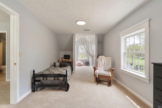 carpeted bedroom featuring multiple windows and baseboards