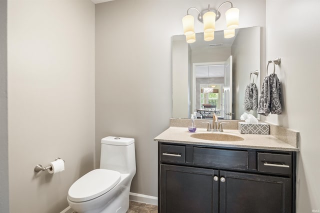 half bath featuring toilet, baseboards, and vanity