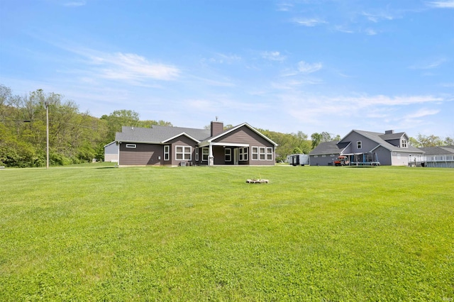 back of property with a yard and a chimney