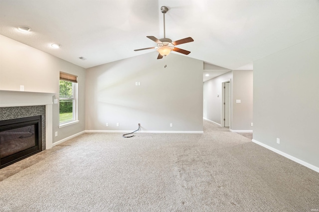 unfurnished living room featuring a tiled fireplace, baseboards, light colored carpet, a ceiling fan, and vaulted ceiling