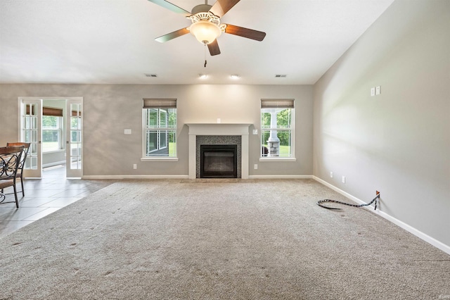 unfurnished living room featuring baseboards, a ceiling fan, a premium fireplace, and carpet