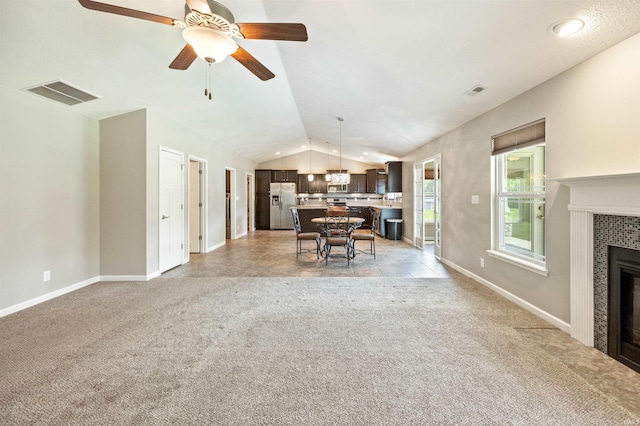 living room with lofted ceiling, a fireplace, ceiling fan, light colored carpet, and baseboards