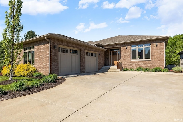 3622 Glenridge Ln, West Lafayette, IN 47906 - prairie-style home featuring an attached garage, concrete driveway, brick siding, and cooling unit