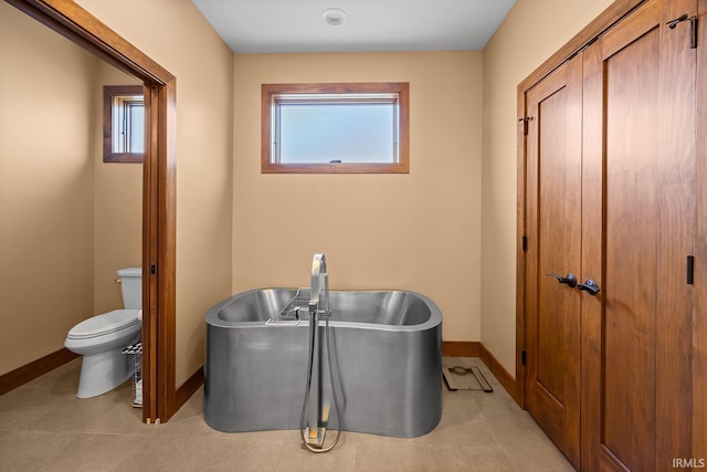 3622 Glenridge Ln, West Lafayette, IN 47906 - bathroom featuring toilet, baseboards, a freestanding tub, and a sink