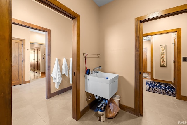 3622 Glenridge Ln, West Lafayette, IN 47906 - laundry area with baseboards, a sink, and light tile patterned flooring