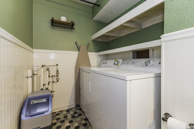 washroom with separate washer and dryer and a wainscoted wall