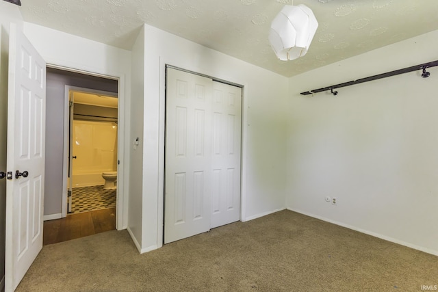 unfurnished bedroom featuring carpet flooring, a closet, and baseboards