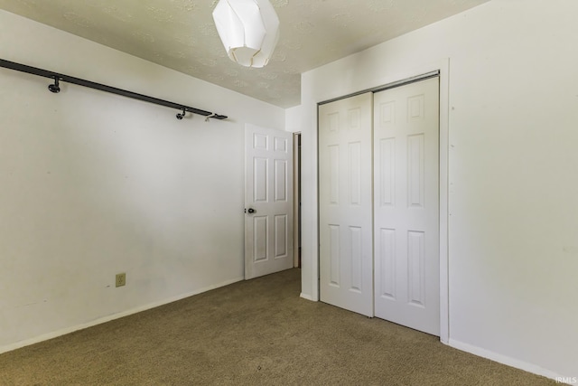 unfurnished bedroom featuring carpet floors, a closet, and baseboards