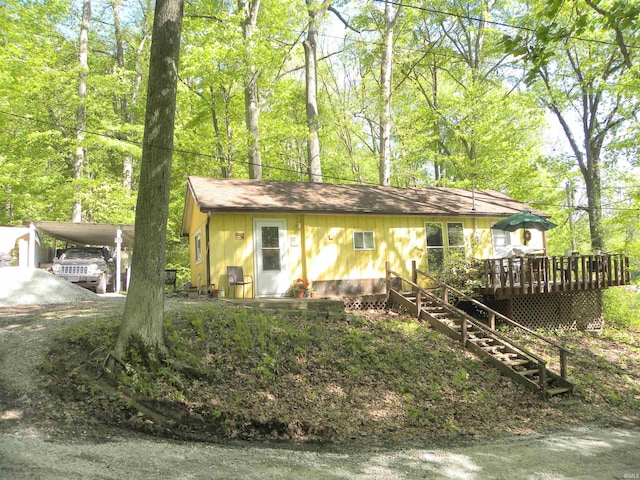 5161 Orange Grove Rd, Gosport, IN 47433 - view of front facade featuring a wooden deck, stairway, a shingled roof, and a carport