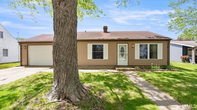 view of front of house featuring an attached garage, driveway, a chimney, and a front lawn