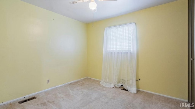 empty room featuring carpet, a ceiling fan, and baseboards