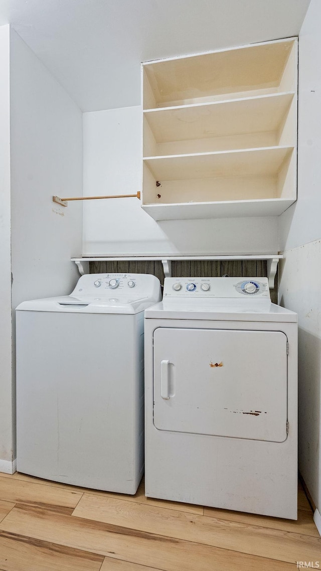 laundry room featuring washing machine and clothes dryer and light wood-style flooring
