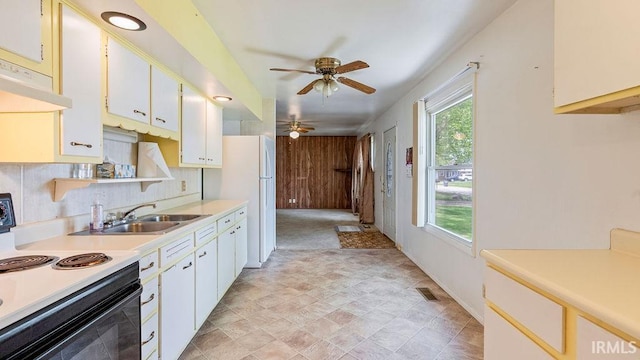 kitchen featuring range with electric stovetop, a sink, a ceiling fan, light countertops, and stone finish floors