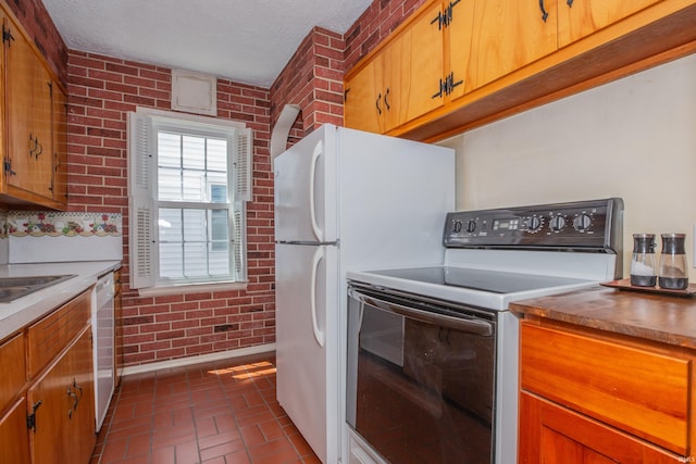927 S Lombard Ave, Evansville, IN 47714 - kitchen with white appliances, brick wall, brick floors, a textured ceiling, and brown cabinets