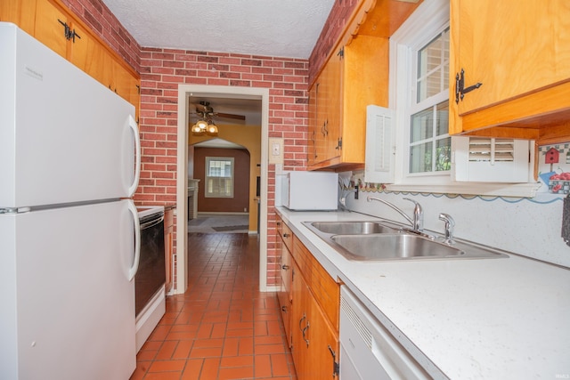 927 S Lombard Ave, Evansville, IN 47714 - kitchen with white appliances, a sink, brick flooring, a ceiling fan, and light countertops