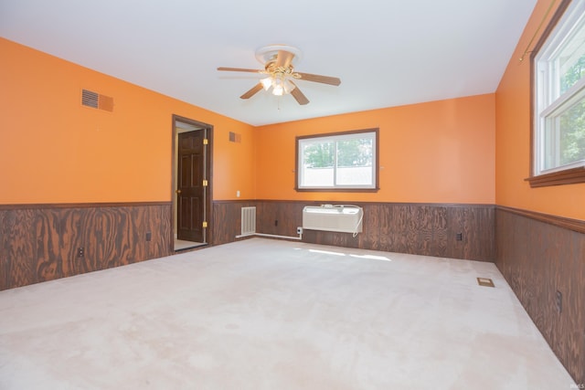 927 S Lombard Ave, Evansville, IN 47714 - spare room with a wainscoted wall, plenty of natural light, a ceiling fan, a wall mounted AC, and carpet floors
