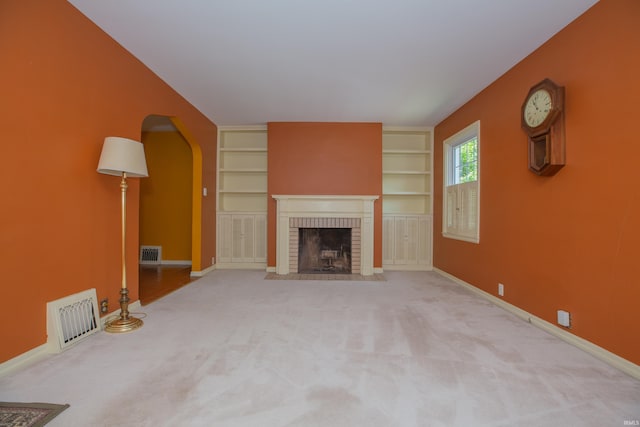 927 S Lombard Ave, Evansville, IN 47714 - unfurnished living room featuring arched walkways, baseboards, and a brick fireplace