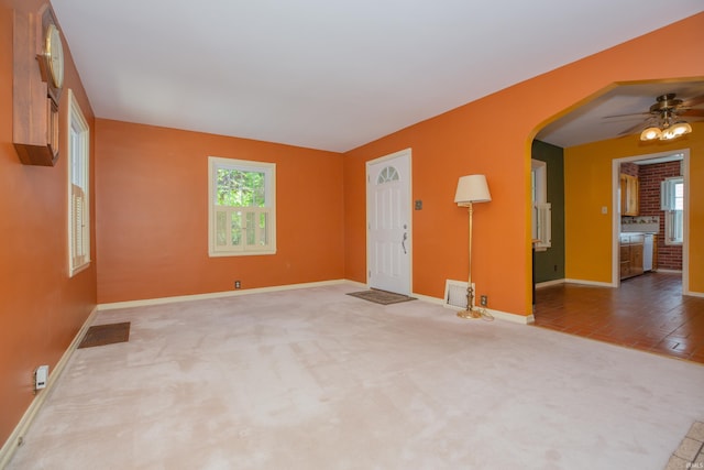 927 S Lombard Ave, Evansville, IN 47714 - unfurnished living room featuring baseboards, arched walkways, carpet flooring, and ceiling fan
