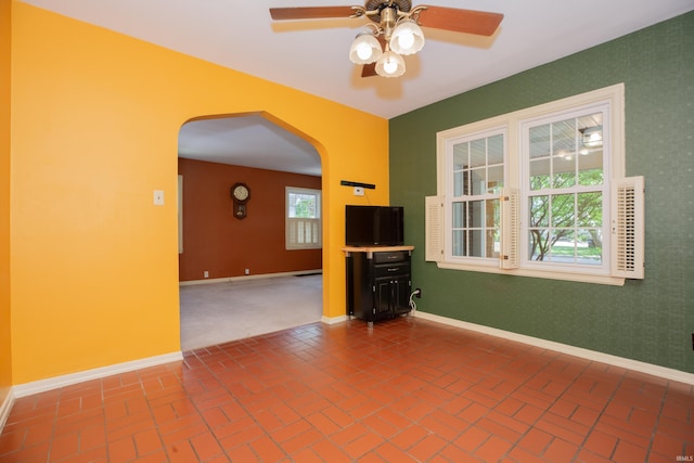 927 S Lombard Ave, Evansville, IN 47714 - unfurnished room featuring arched walkways, a ceiling fan, baseboards, and brick flooring