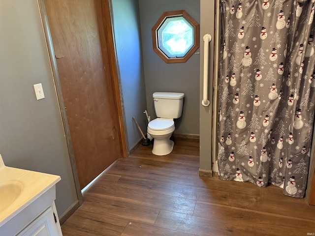 bathroom featuring hardwood / wood-style floors, toilet, vanity, and baseboards