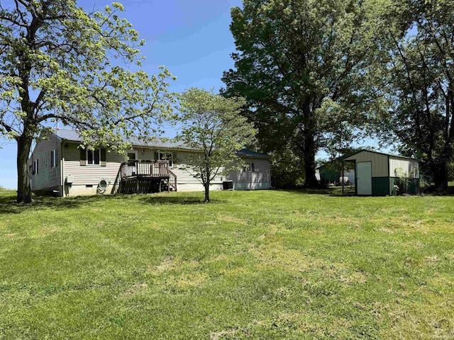 view of green lawn with an outdoor structure and a deck