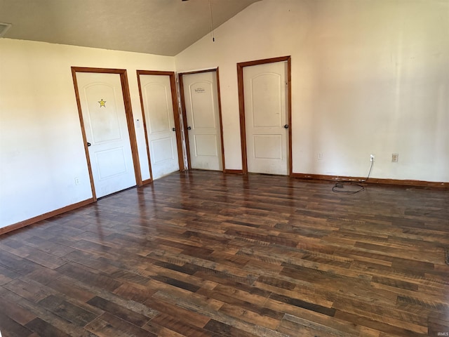 unfurnished bedroom with dark wood-style flooring, vaulted ceiling, and baseboards
