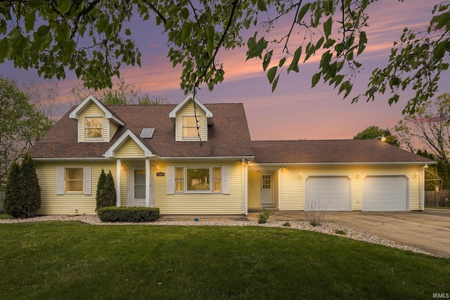 cape cod-style house with driveway, an attached garage, and a front yard