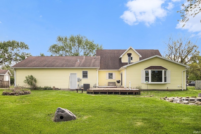 rear view of property with a wooden deck, central AC, an outdoor fire pit, and a yard