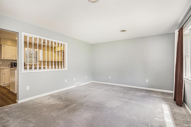 carpeted empty room featuring baseboards