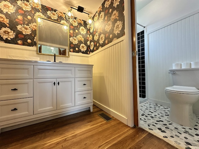 100 Lincoln St, Plainfield, IN 46168 - full bath with wainscoting, wallpapered walls, wood finished floors, toilet, and vanity