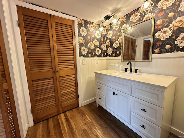 100 Lincoln St, Plainfield, IN 46168 - bathroom featuring a wainscoted wall, wallpapered walls, wood finished floors, and vanity