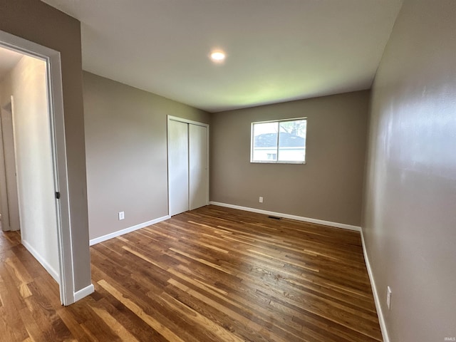 100 Lincoln St, Plainfield, IN 46168 - unfurnished bedroom featuring dark wood finished floors, baseboards, and a closet