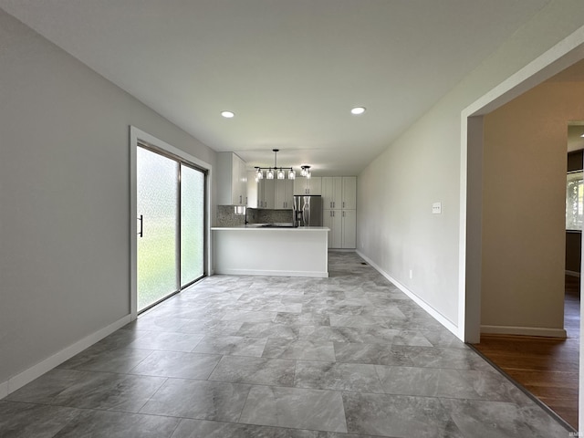 100 Lincoln St, Plainfield, IN 46168 - unfurnished living room with baseboards, recessed lighting, and a chandelier