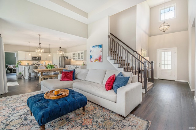 7828 E Cherokee Rd, Syracuse, IN 46567 - living room featuring healthy amount of natural light, a high ceiling, dark wood-style flooring, stairway, and baseboards