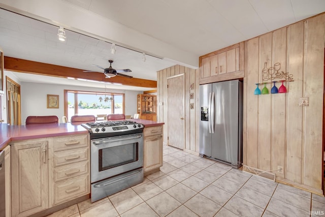 kitchen featuring appliances with stainless steel finishes, light brown cabinetry, rail lighting, wood walls, and light tile patterned flooring