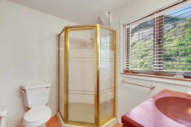 bathroom with a shower stall, toilet, a sink, and baseboards