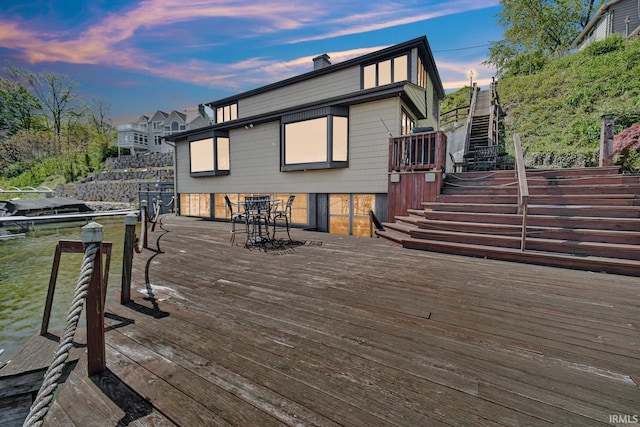 wooden terrace with stairway and outdoor dining space