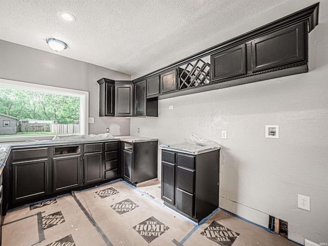 630 E Water St, Mount Vernon, IN 47620 - kitchen featuring a textured ceiling, dark cabinets, and light countertops
