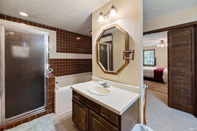 ensuite bathroom with a textured ceiling, wallpapered walls, a shower stall, a garden tub, and vanity