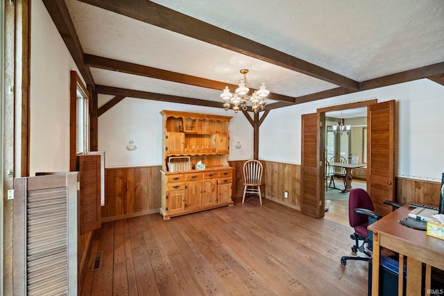 office with a chandelier, wainscoting, wooden walls, light wood finished floors, and beam ceiling