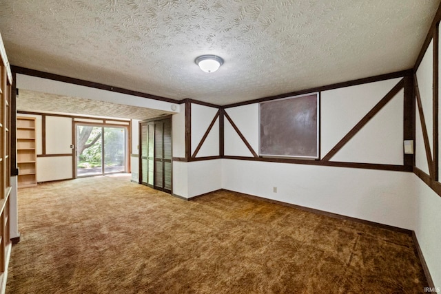 carpeted spare room with a textured ceiling and baseboards