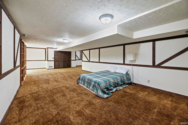 carpeted bedroom with a textured ceiling and baseboards
