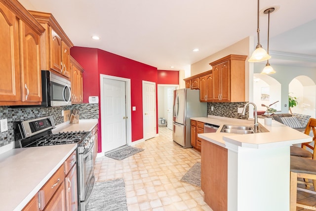 kitchen featuring appliances with stainless steel finishes, a sink, a kitchen breakfast bar, light countertops, and recessed lighting