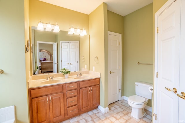 full bath featuring toilet, double vanity, baseboards, and a closet