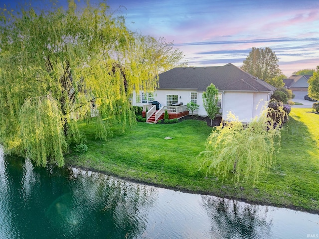 exterior space featuring a deck with water view and an attached garage