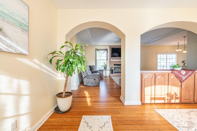 hall with light wood-style floors, healthy amount of natural light, and baseboards